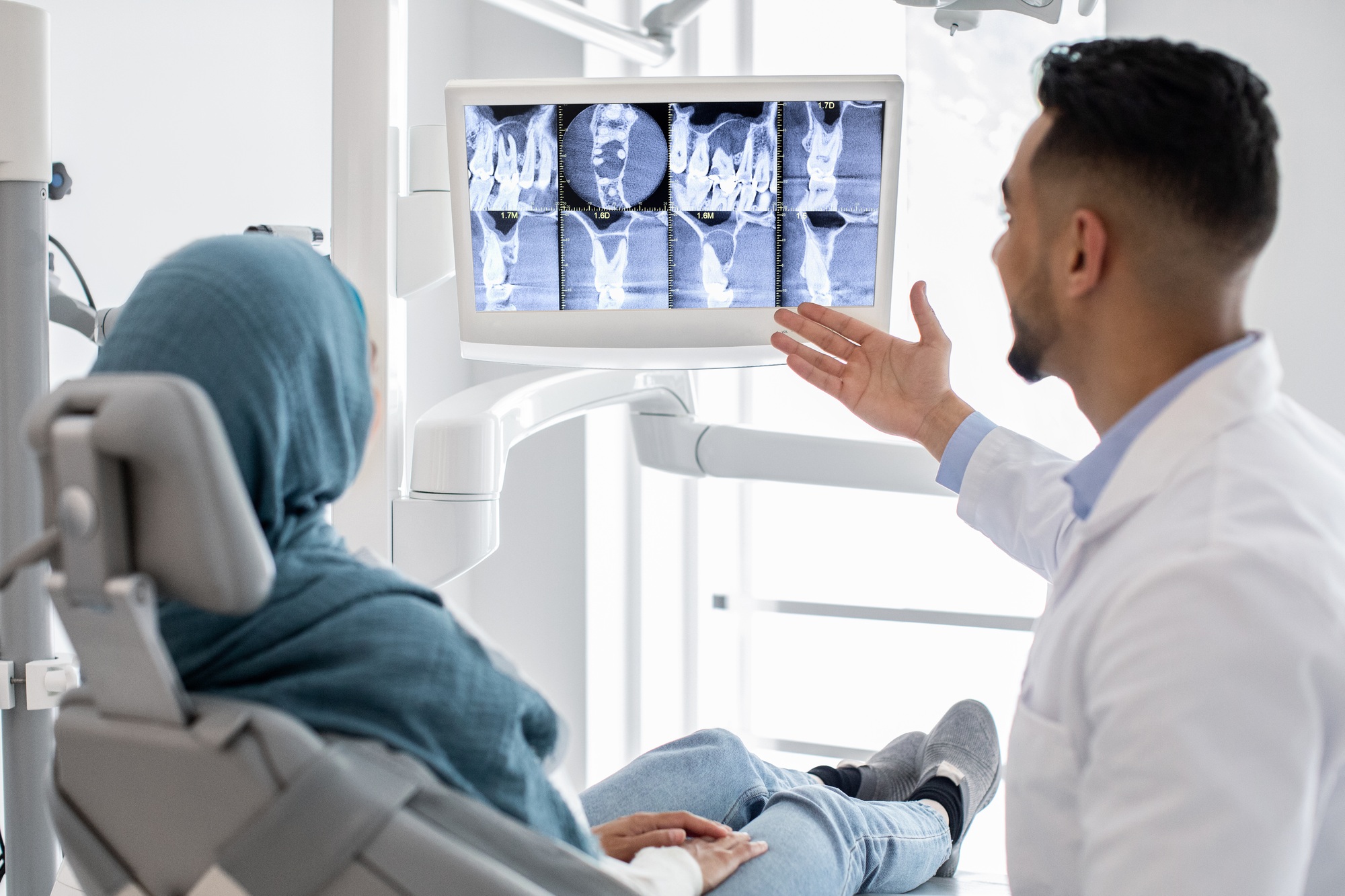 Arab Male Dentist Showing Treatment Result At Teeth Xray To Muslim Patient